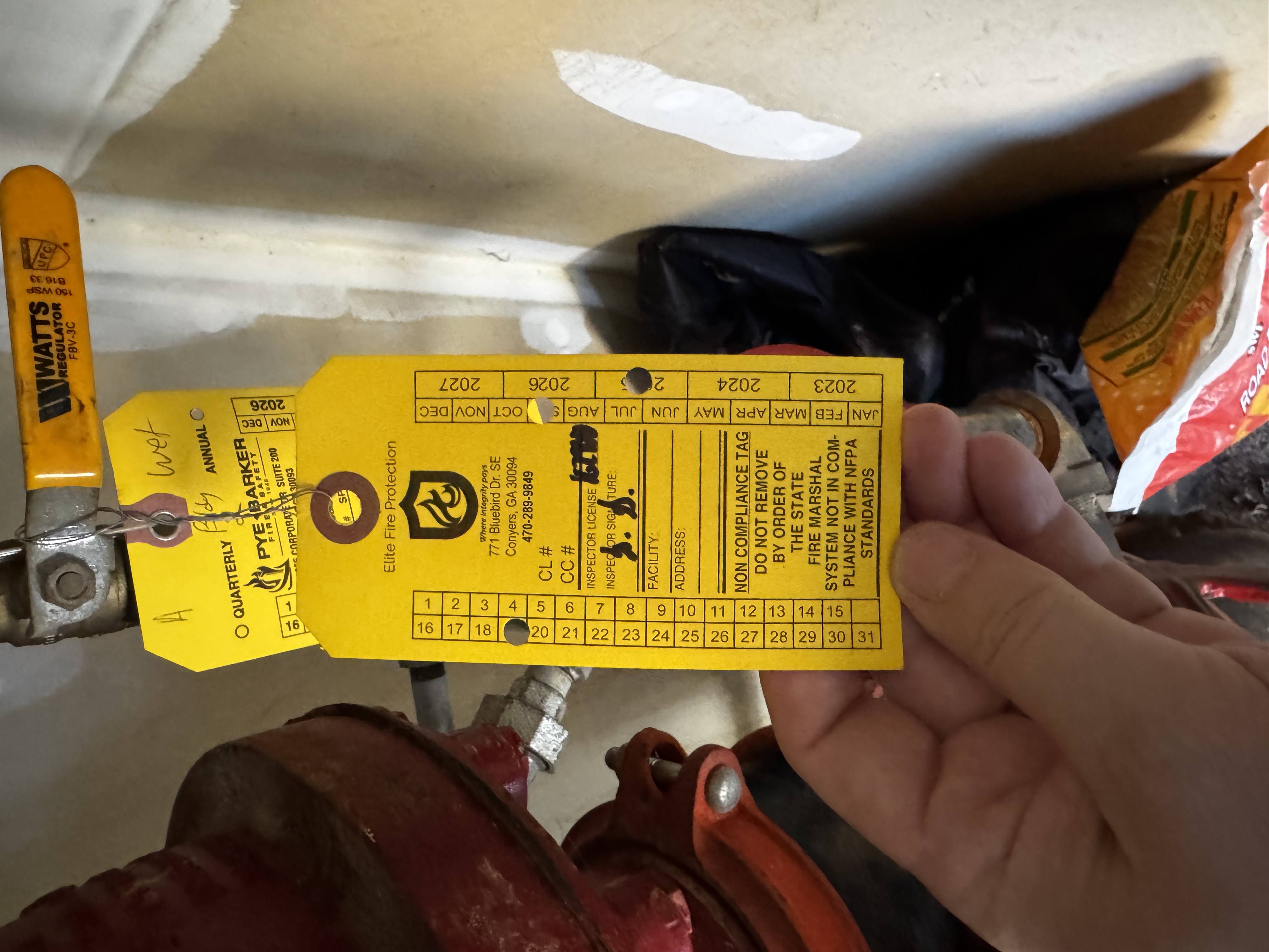 NON-COMPLIANCE tag on sprinkler system riser, January 16, 2026